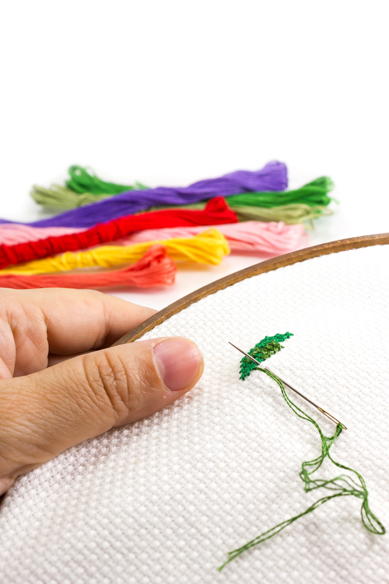 Close-up of hand embroidery on linen with colorful threads